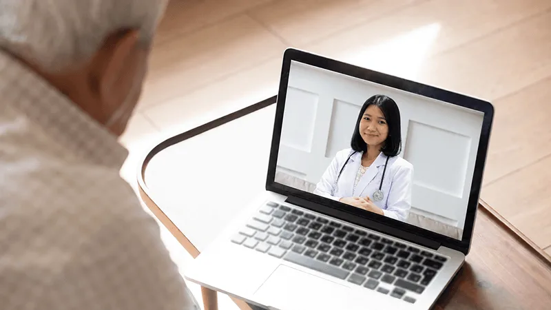 Pasien sedang konsultasi video dengan dokter di layar laptop